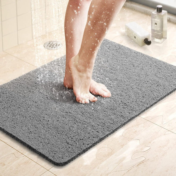 Gray shower mat laid out on a bathroom floor