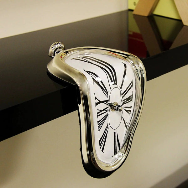 A surreal melting silver clock draped over a bookshelf edge.