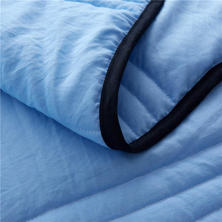 Cooling blanket laid out flat on a bed