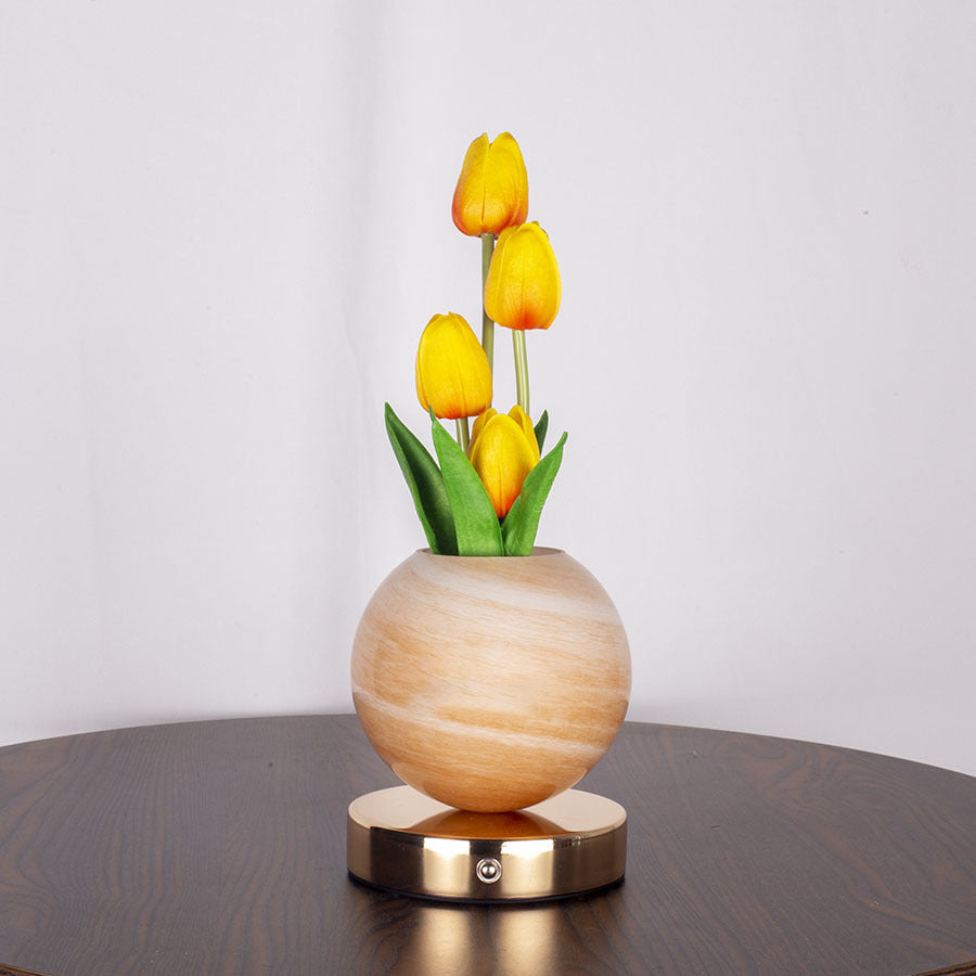 Tulip table lamp glowing on a living room shelf