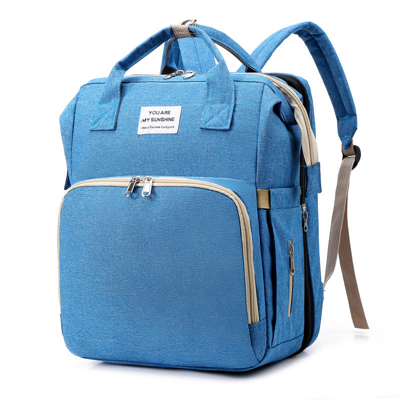 Diaper bag backpack standing upright on a flat surface.
