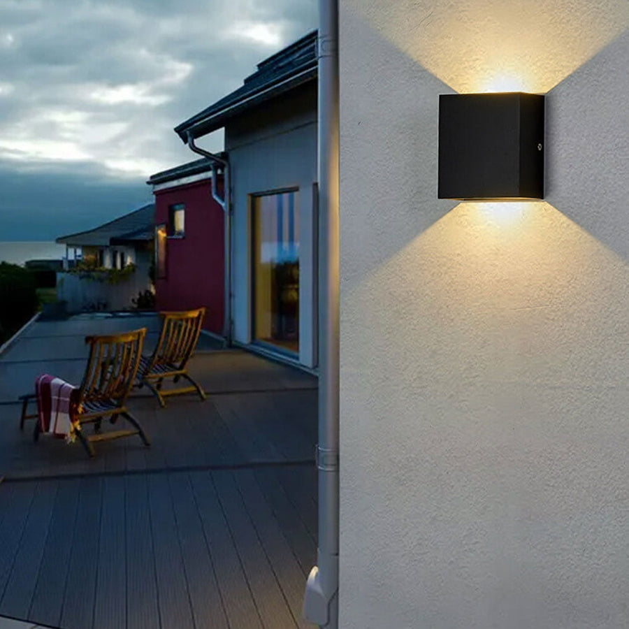 Outdoor wall lamp glowing with warm light at dusk