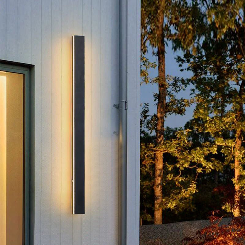 Wall light glowing softly near an outdoor seating nook