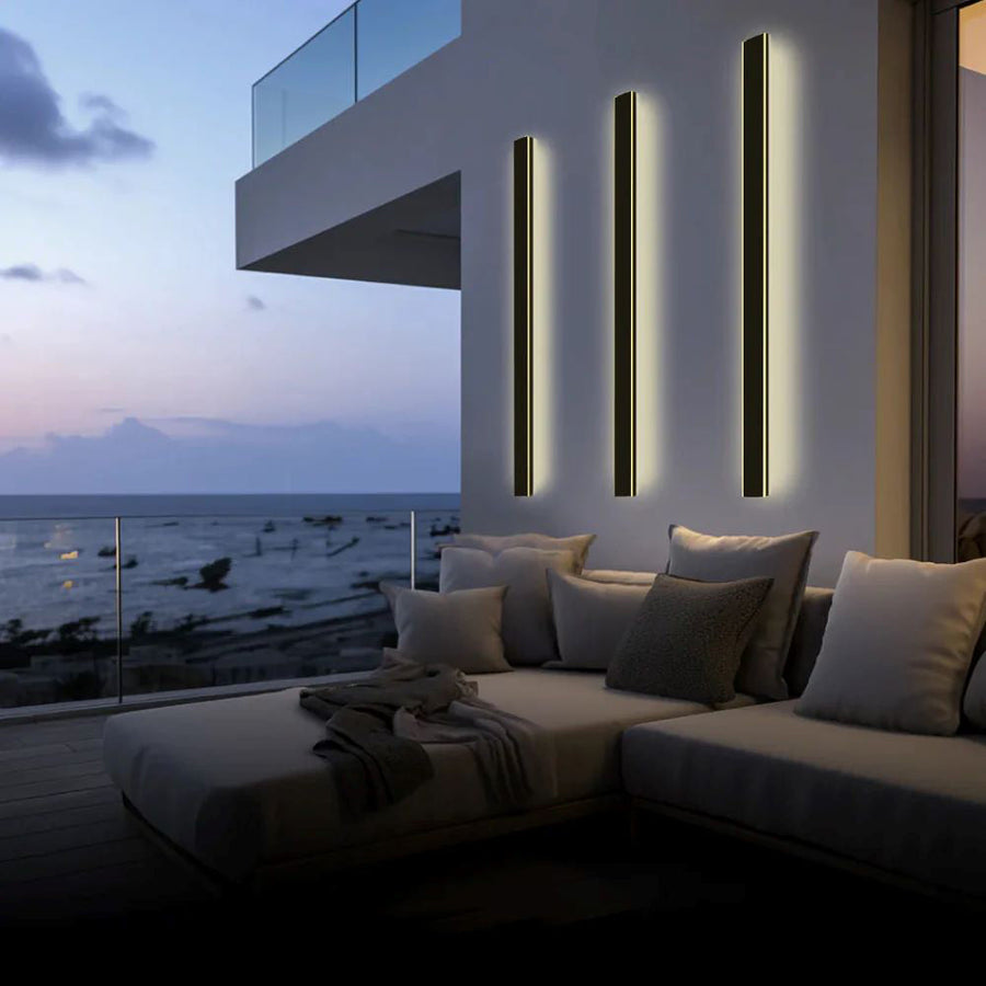 Outdoor wall light glowing warm white at dusk