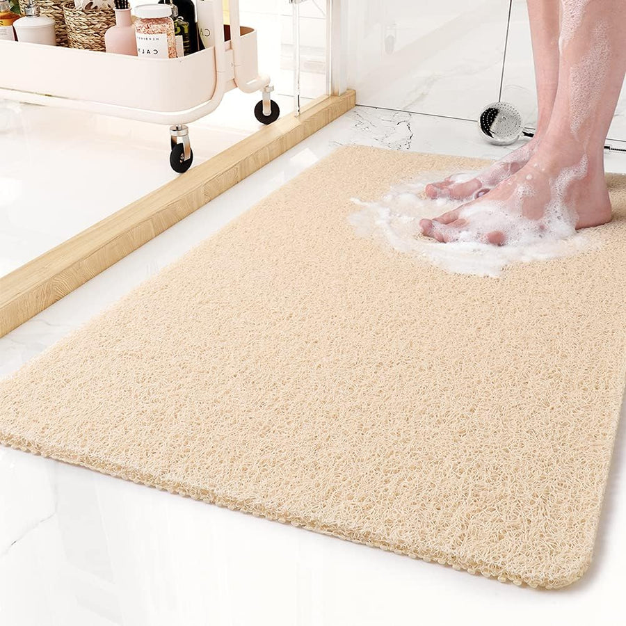 Yellow shower mat placed beside a bathtub