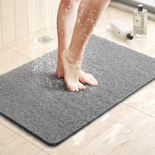 Gray shower mat laid out on a bathroom floor