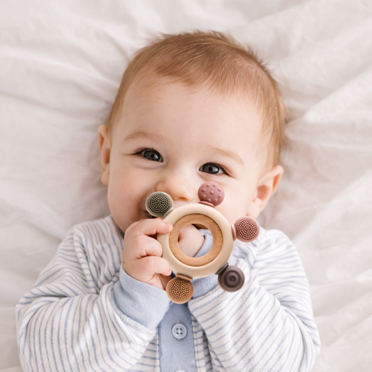 Silicone and wood baby teething ring on a plain background.