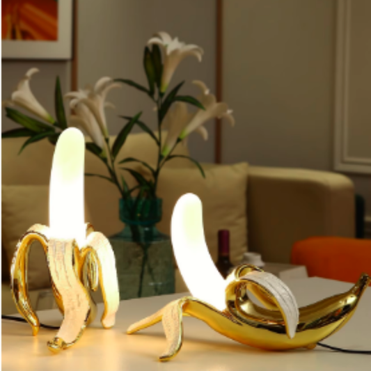 Banana-shaped table lamp glowing on a nightstand