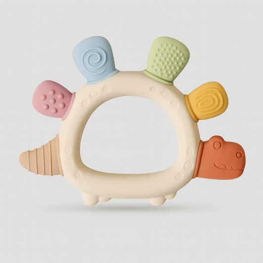 Dinosaur-shaped silicone teething ring with pastel textured bumps.