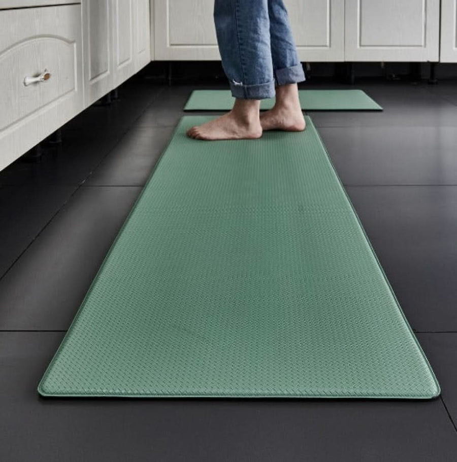 Black kitchen mat placed in front of a kitchen counter.