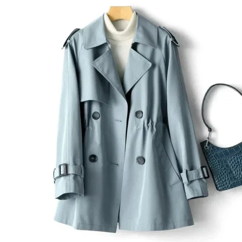 Woman standing in a long belted trench coat