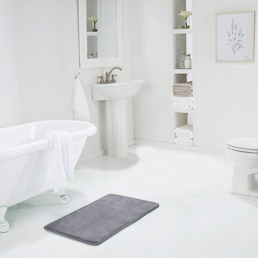 Navy blue bath mat displayed on a wooden floor