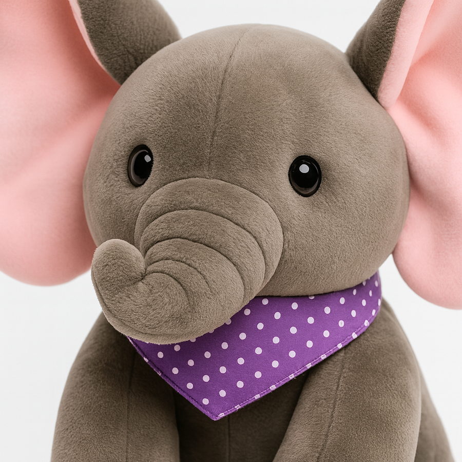 Close-up of a stuffed elephant's soft pink ears and embroidered face