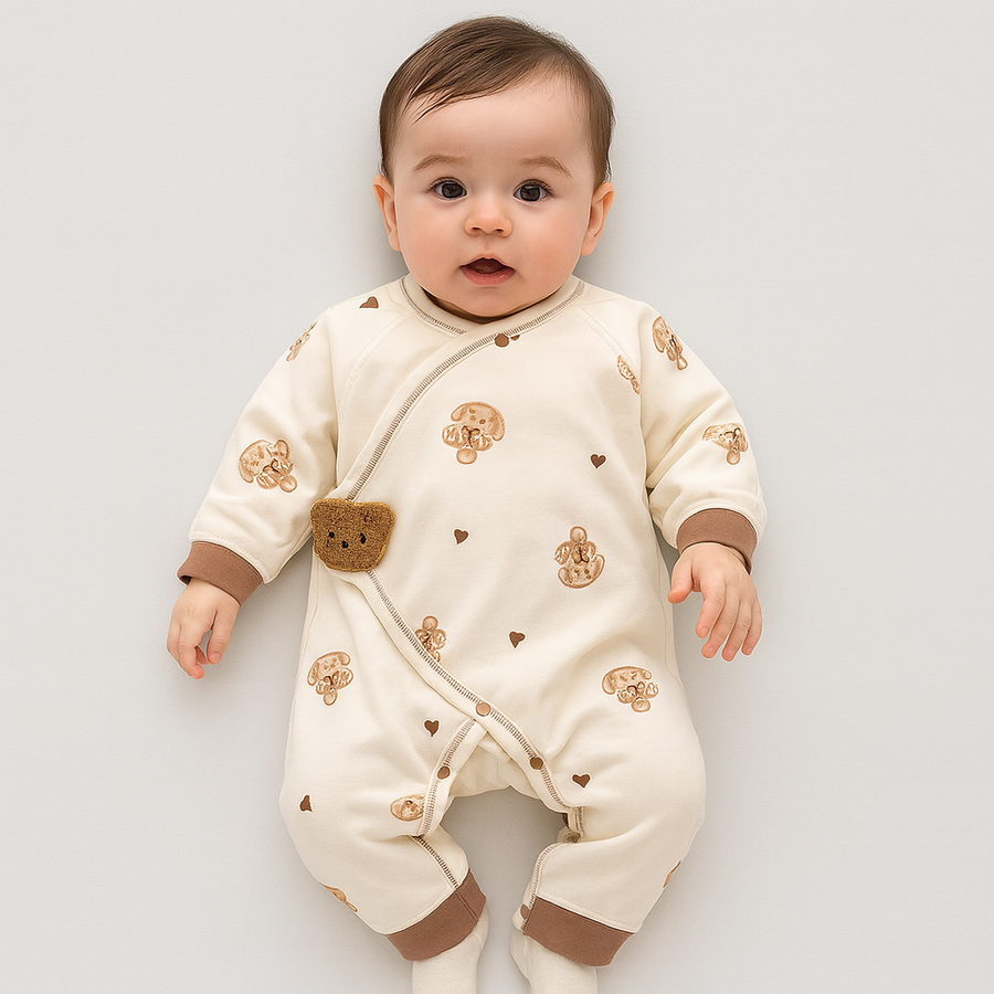 Close-up of the crocheted bear applique on a cream baby footie