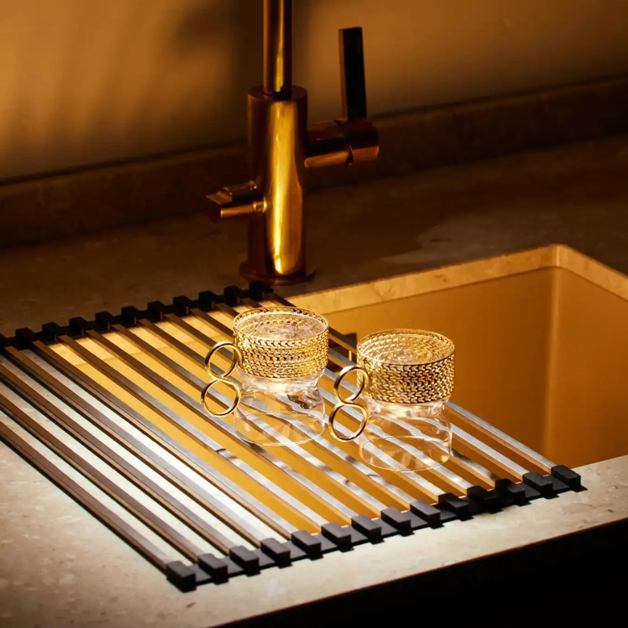 Roll-up dish drying rack placed over a kitchen sink.