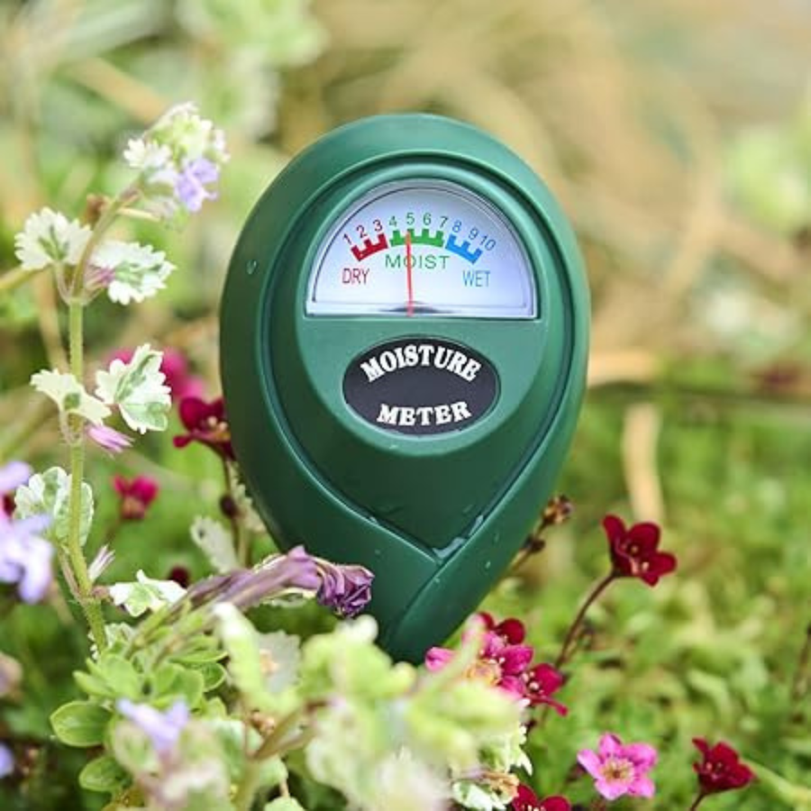 Person using the soil moisture meter in a garden bed