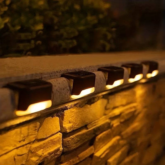 Solar-powered outdoor lights installed along a railing at dusk