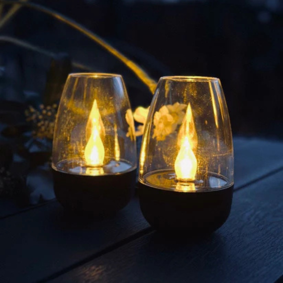 Close-up of the glass and steel lantern with a soft flame reflection.