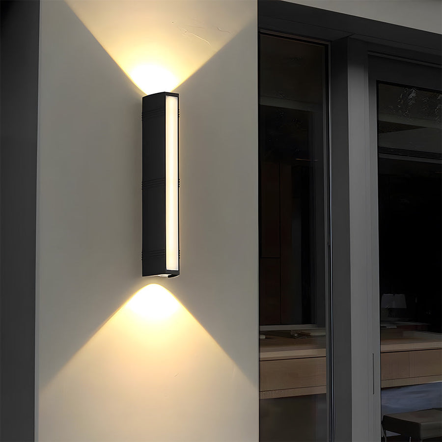 Outdoor wall light mounted beside a garden pathway