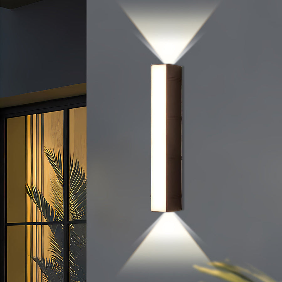 Outdoor wall light illuminated at dusk on a patio