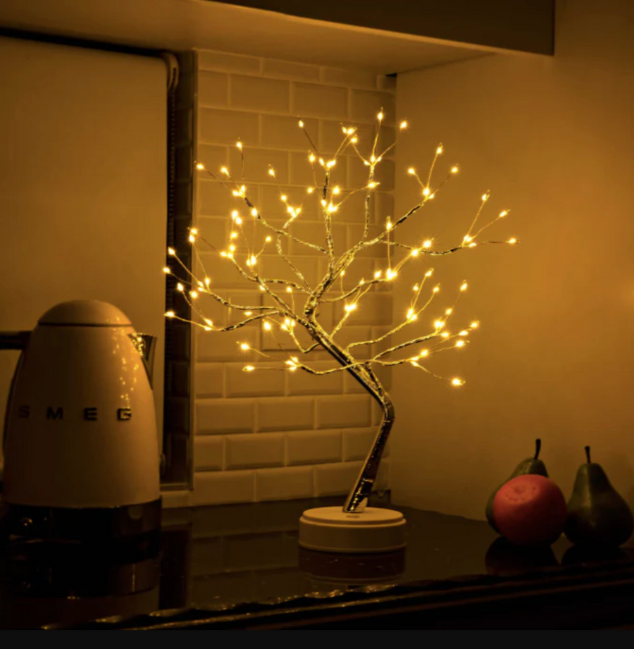 Modern LED tree table lamp lit up in a dark room