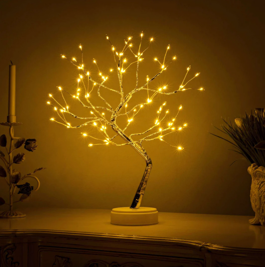 Gold-toned LED tree table lamp on a nightstand