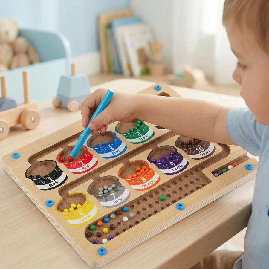 Child using the magnetic pen to sort colored beads on the board.