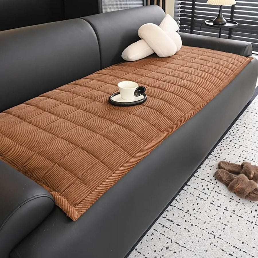 Modern quilted sofa cover draped over a sofa