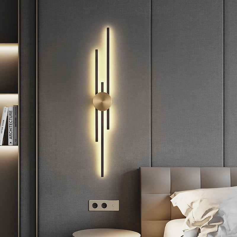 Black and gold linear wall sconce mounted on a light gray wall