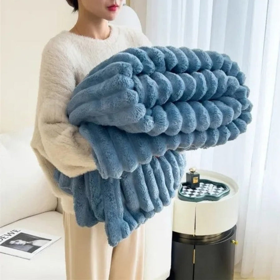 Striped blanket laid out on a bed in a bedroom