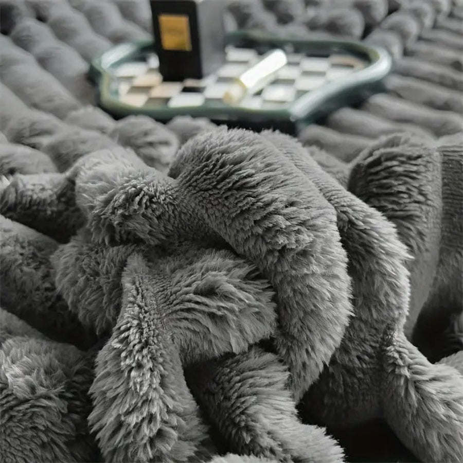 Fluffy blanket in blush pink draped over furniture