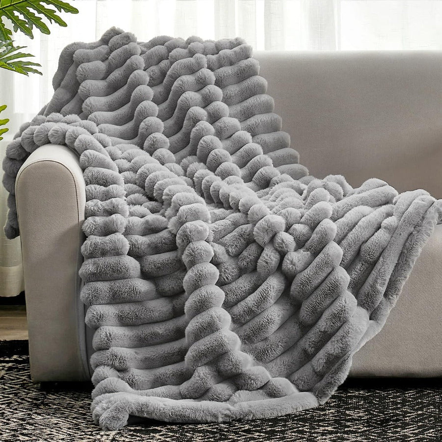 Fluffy warm striped blanket draped over a couch