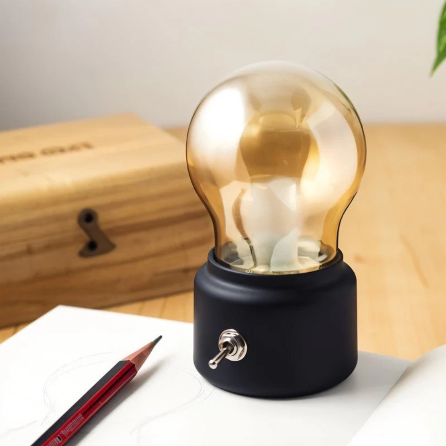 Black retro bulb lamp glowing warmly in a dark room