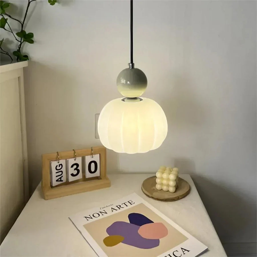 Pendant light in red finish mounted above a dining table
