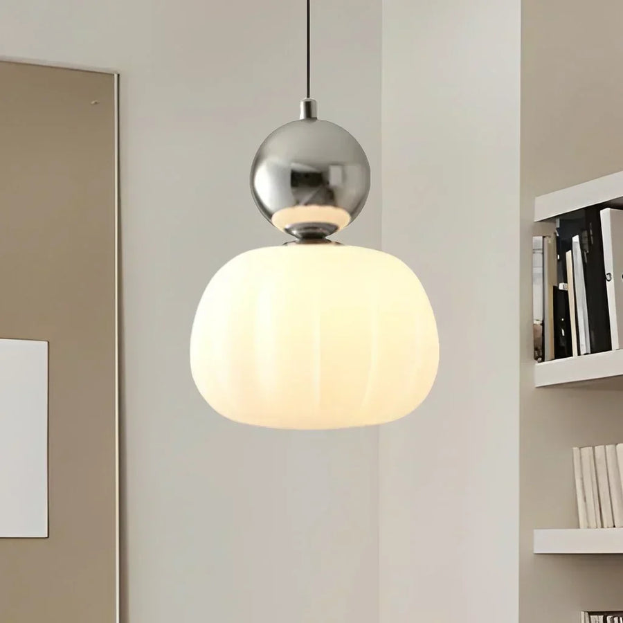 Beige pendant light hanging over a bedside table