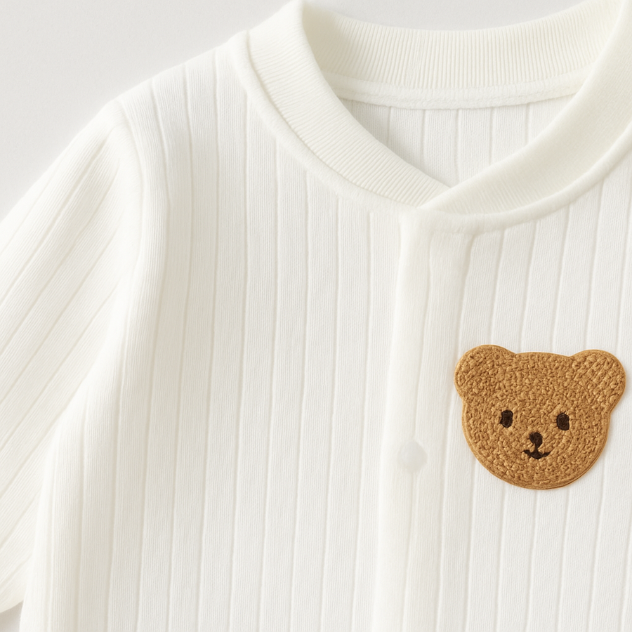 Baby overall with snap buttons and a crocheted bear applique