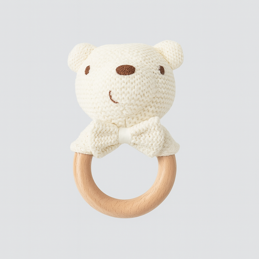 Cream-colored knit bear rattle with wood ring and soft bow