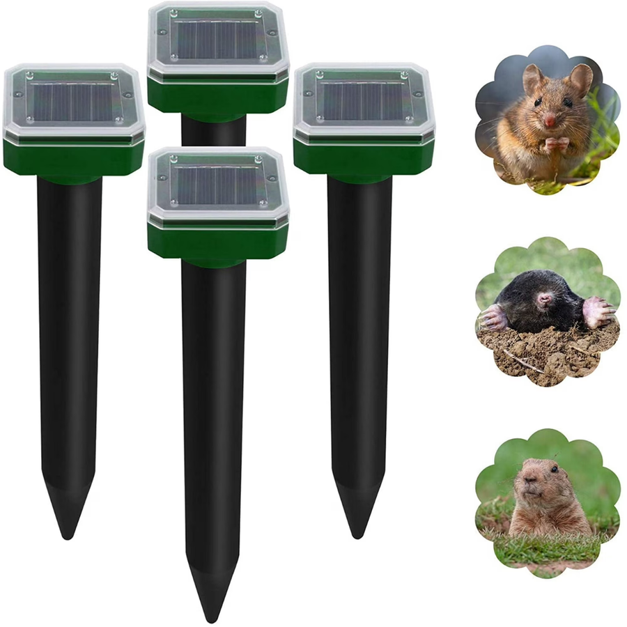 Solar rodent repellent stake standing in garden soil