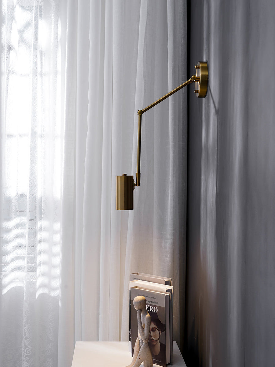 Gold wall sconce mounted above a nightstand