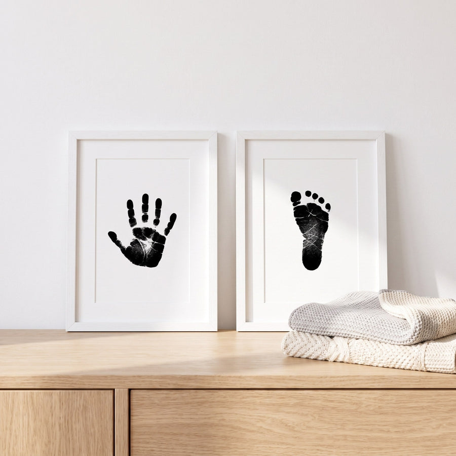 Hand and footprints framed side by side on a dresser