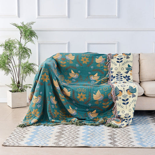 Reversible Scandinavian bird throw blanket draped over a sofa