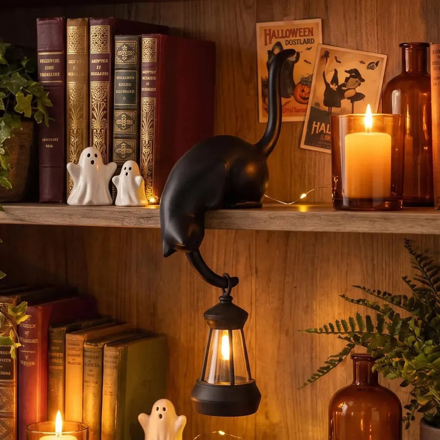Black cat figurine with lantern in fall decor