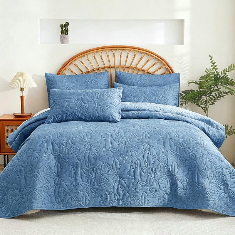 Blue quilted bedding set on a round rattan headboard bed