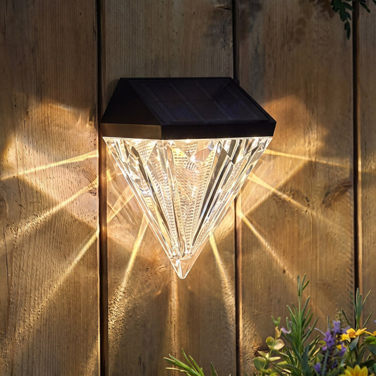 The diamond light scatters star patterns on the fence at dusk