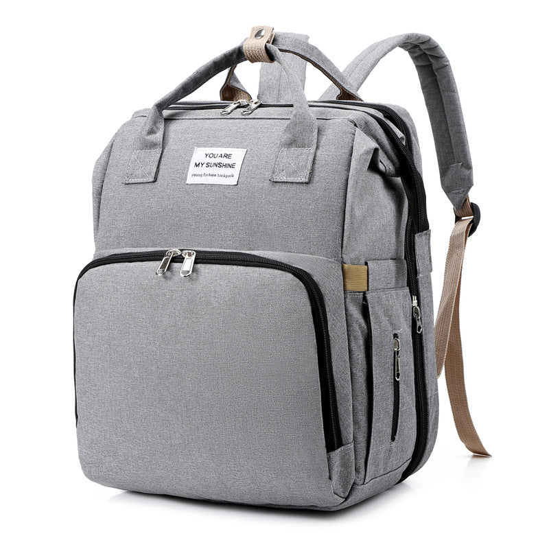 Parent wearing the diaper bag backpack on their shoulders.
