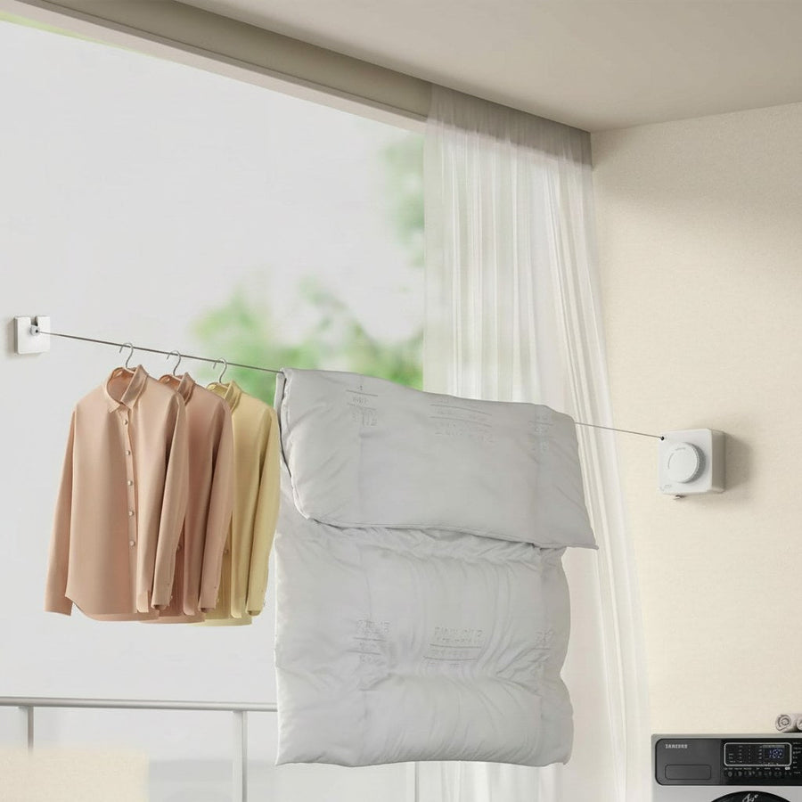 Clothesline mounted on a wall with clothes and a pillow hanging