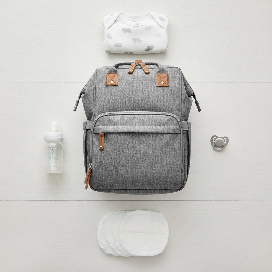 Top view of diaper backpack surrounded by diapers, a bottle, and a pacifier