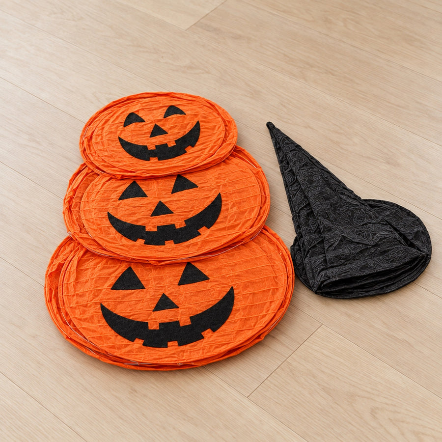 Pumpkin decoration collapsed flat next to folded witch hat