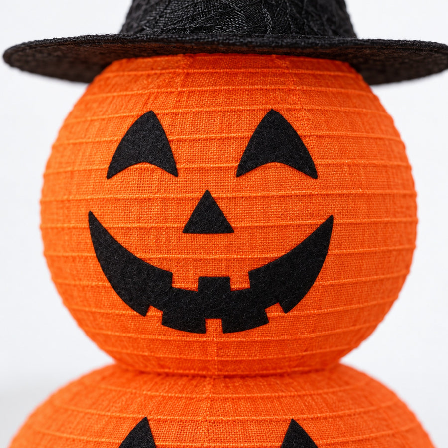 Close-up of ribbed orange fabric and black felt face