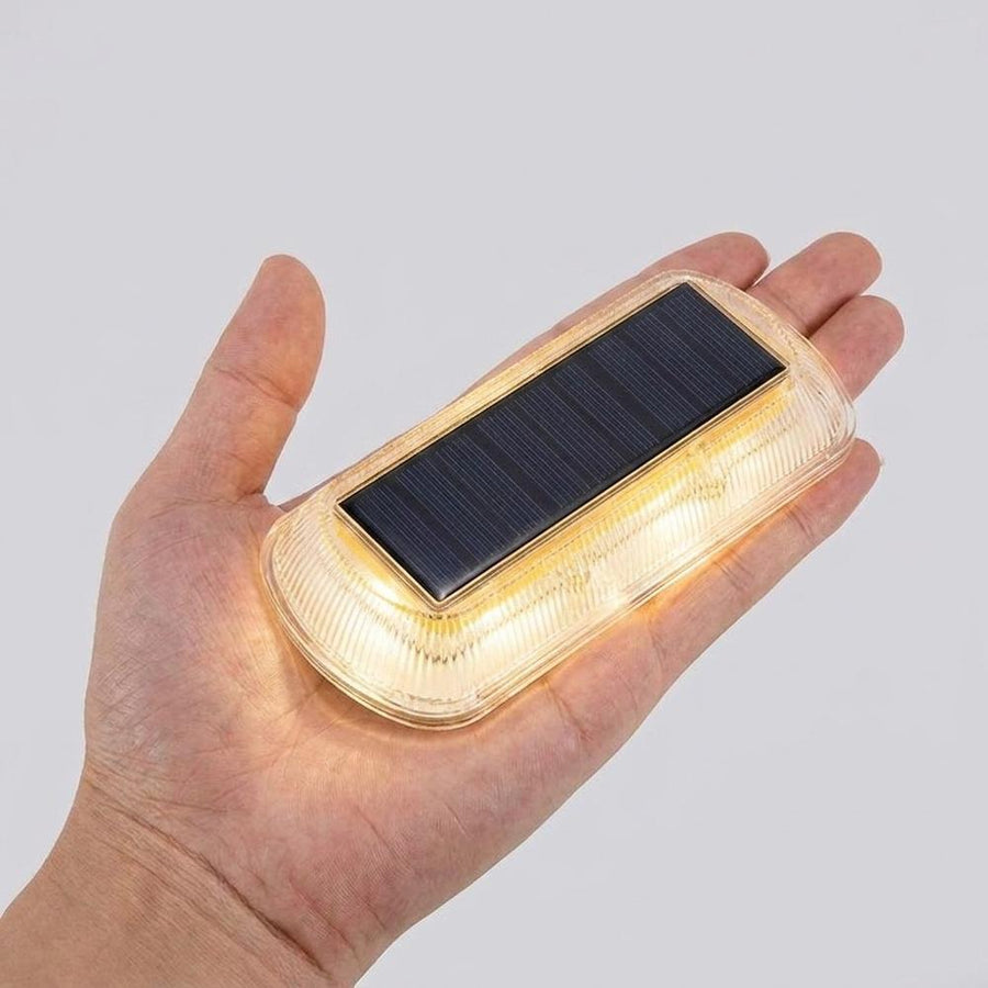Hand holding solar LED step light showing compact size